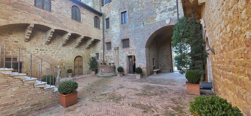 Stone courtyard of the medieval buildings at Palazzo Massaini