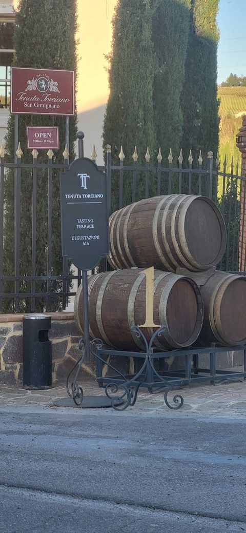 The Tenuta Torciano sign among barrels