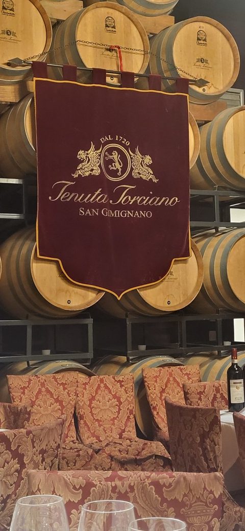Tenuta Torciano sign among wine barrels